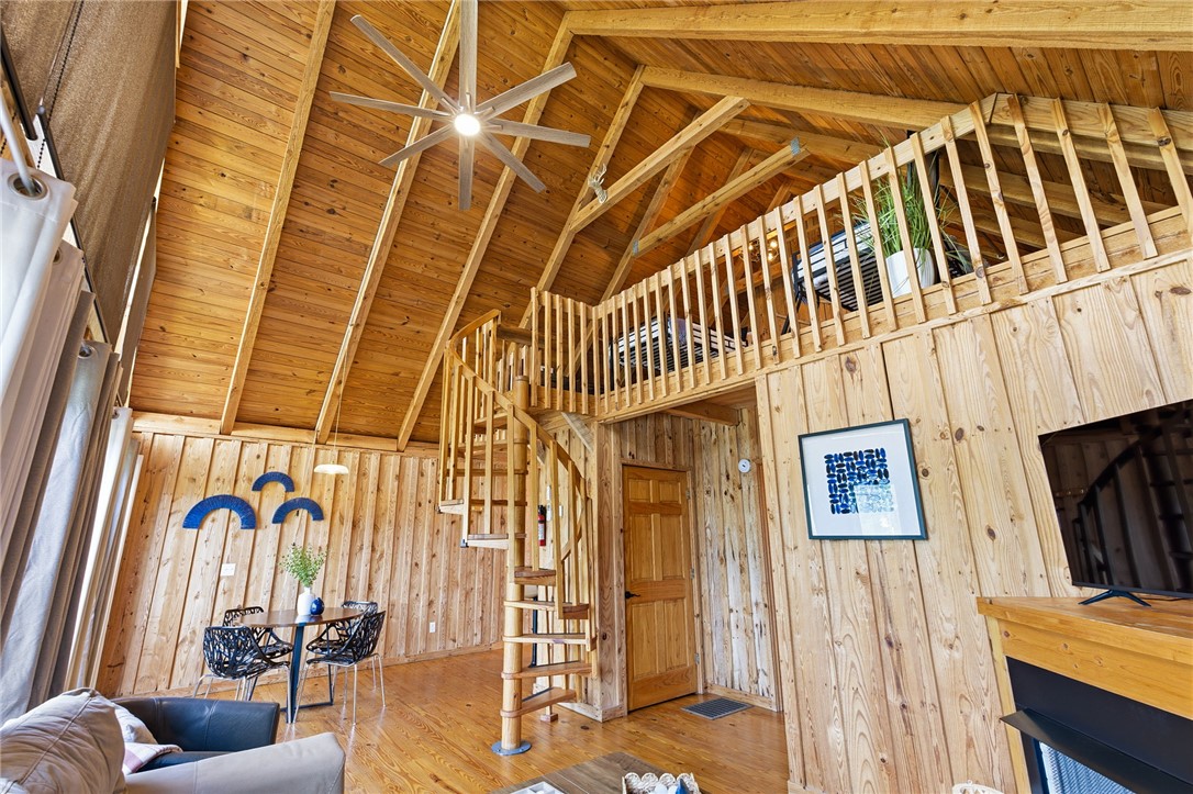 1 Kitty Hawk Lane Six Mile, SC 29682 - Photo 46 of 46 This living space features warm wood paneling, an open floorplan, and a charming spiral staircase leading to a loft.