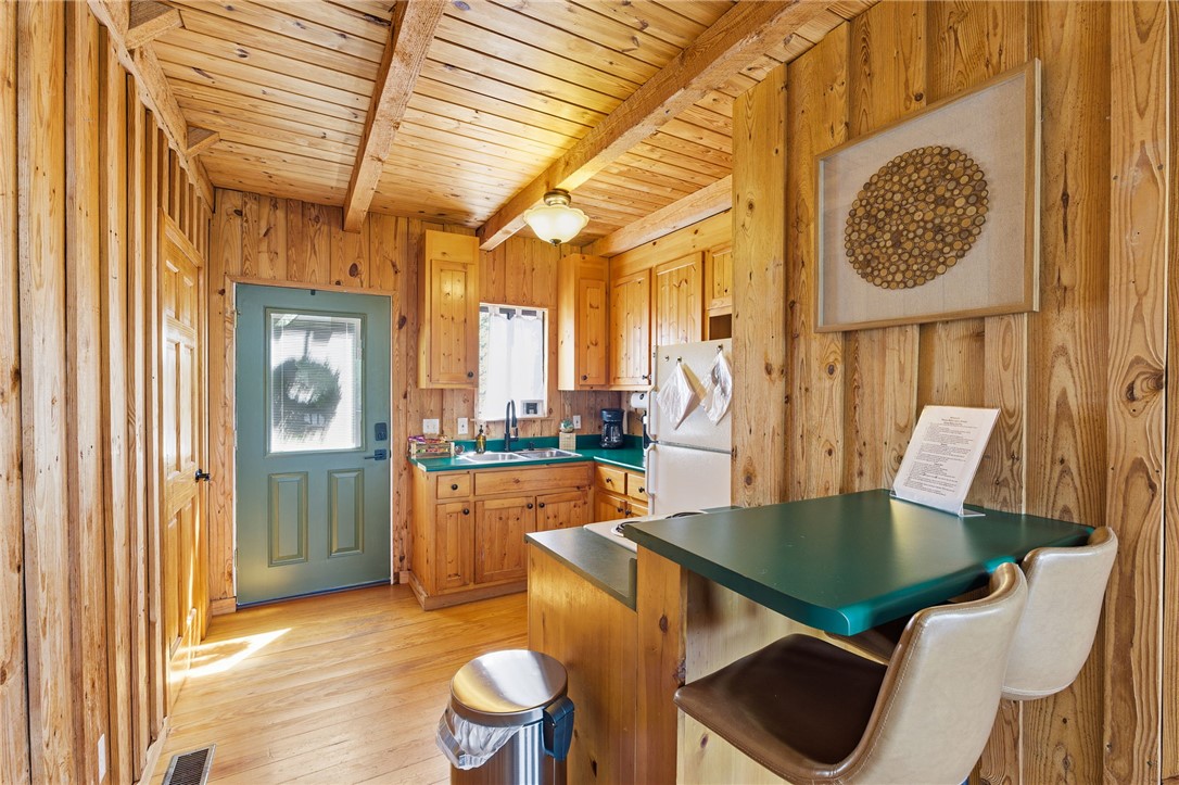 1 Kitty Hawk Lane Six Mile, SC 29682 - Photo 13 of 46 This cozy kitchen features rustic wood paneling and exposed beam ceilings, creating a warm, inviting atmosphere.