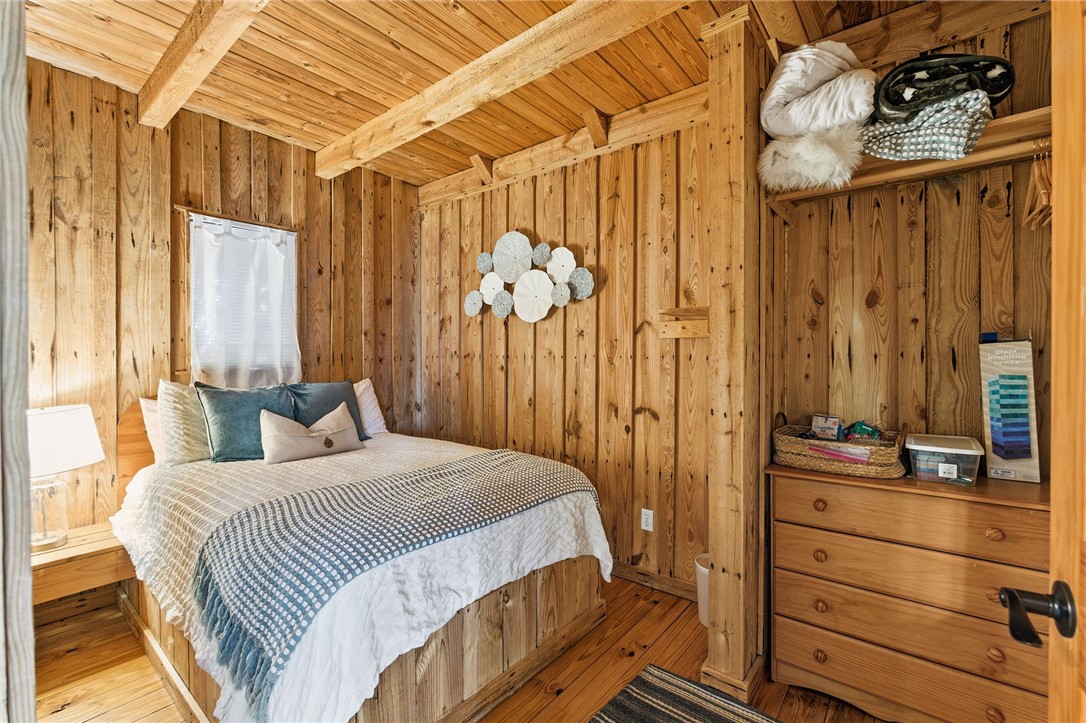 1 Kitty Hawk Lane Six Mile, SC 29682 - Photo 19 of 46 This cozy bedroom features rustic wooden walls and exposed beams, offering a warm and inviting retreat.