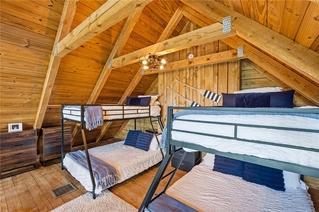 1 Kitty Hawk Lane Six Mile, SC 29682 - Photo 22 of 46 This cozy bedroom features exposed wooden beams and rich wood paneling, creating a rustic and inviting atmosphere.