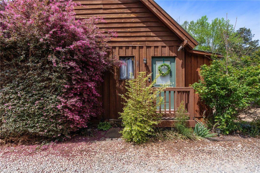 1 Kitty Hawk Lane Six Mile, SC 29682 - Photo 6 of 46 This charming home features rustic wood siding and a welcoming entrance, nestled among vibrant greenery.