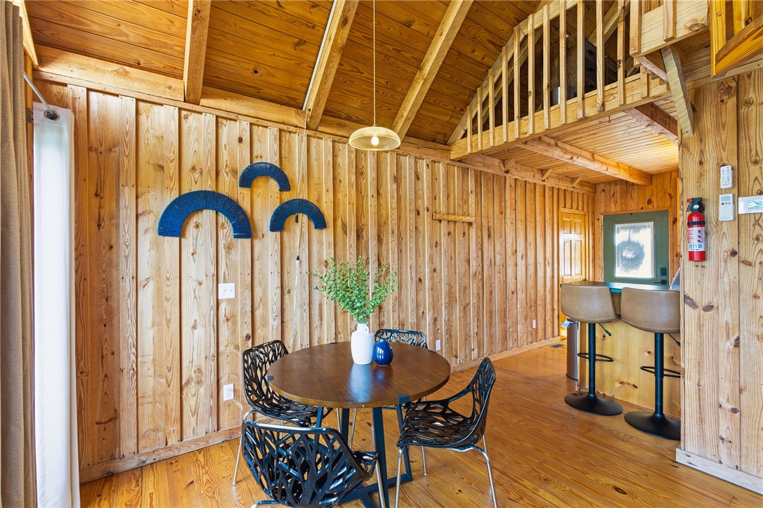 1 Kitty Hawk Lane Six Mile, SC 29682 - Photo 7 of 46 This inviting dining area features warm wooden walls, floors, and a charming kitchen bar.