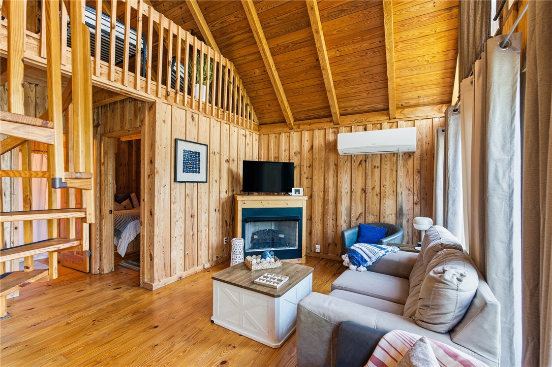1 Kitty Hawk Lane Six Mile, SC 29682 - Photo 9 of 46 This warm living space features rich wood paneling, a charming fireplace, and a cozy loft area.