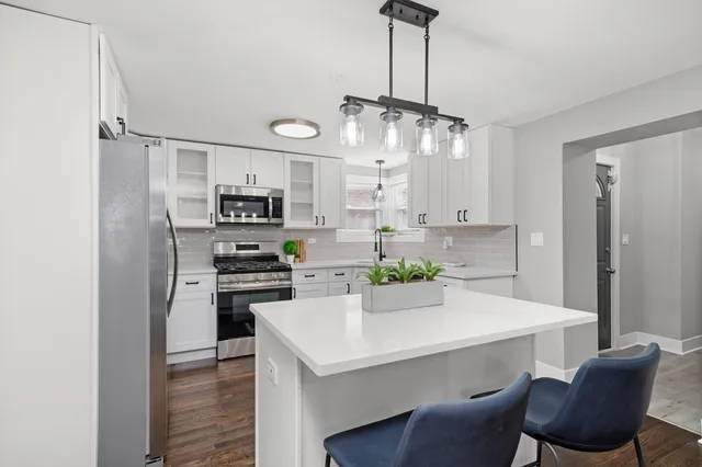 a kitchen with cabinets a counter space stainless steel appliances and cabinets