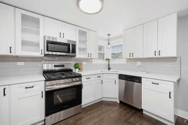 a kitchen with cabinets stainless steel appliances a sink and a stove