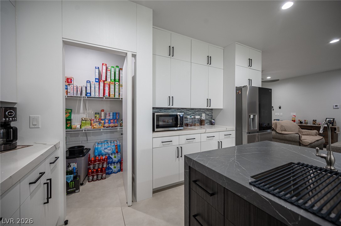 441 Belville Road Pahrump, NV 89048 - Photo 14 of 44 A well-organized pantry complements this sleek kitchen, complete with a generous island and modern appliances.