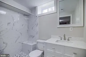 a bathroom with a toilet sink a mirror and shower