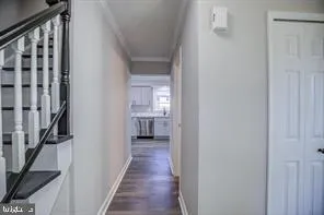 a view of a hallway with wooden floor and staircase