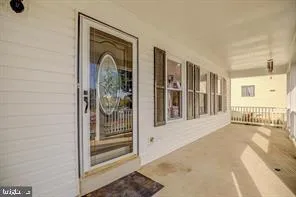 a view of a hallway with wooden floor and a livingroom