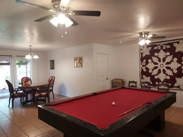 a room with furniture pool table and chandelier