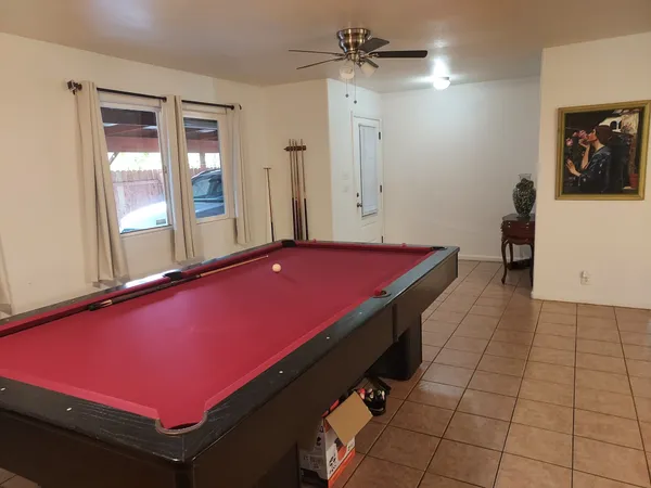 a room with pool table and windows