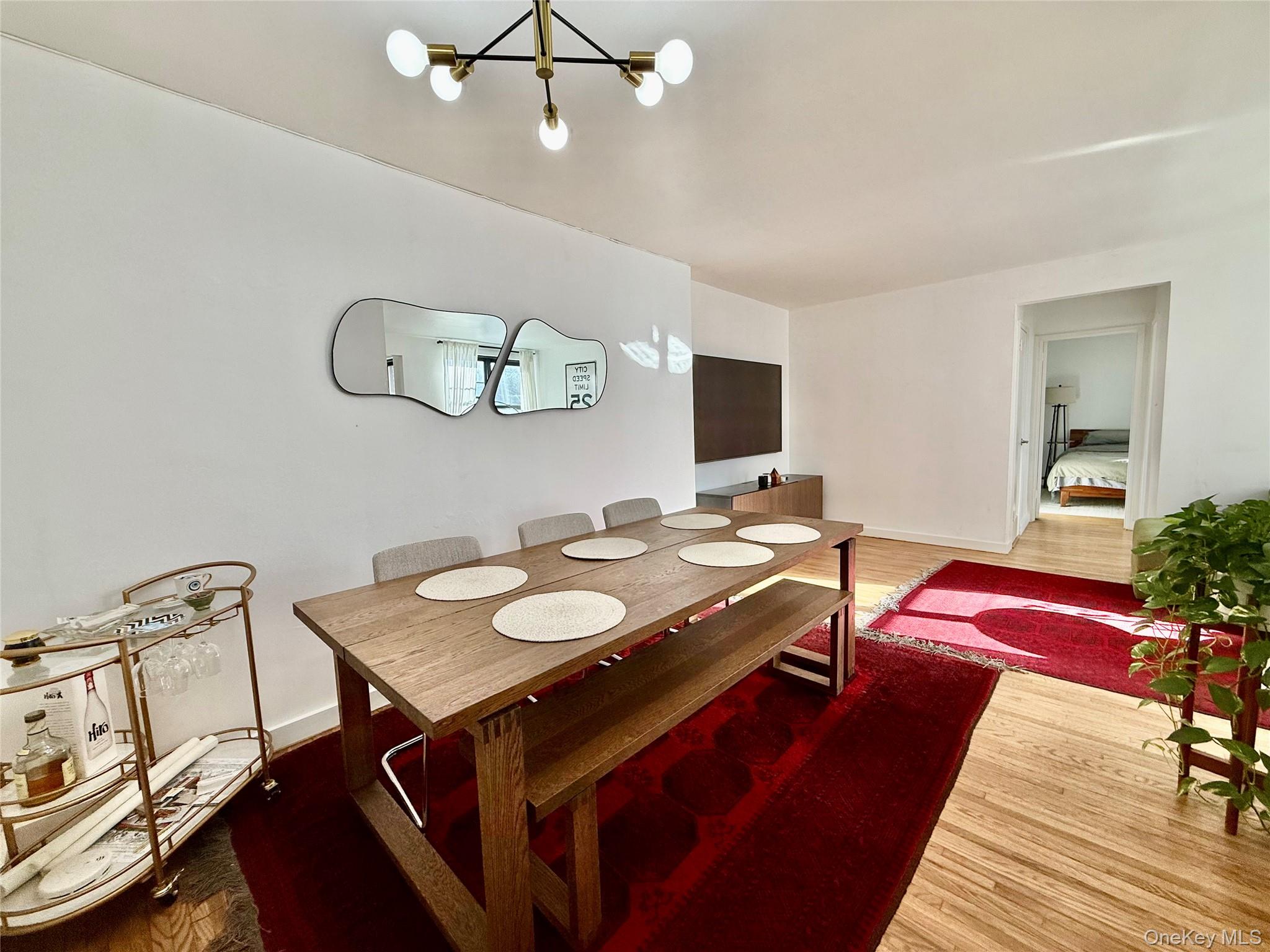 112-30 Northern Boulevard, Unit 2A Queens, NY 11368 - Photo 12 of 40 Dining area featuring wood finished floors and a chandelier