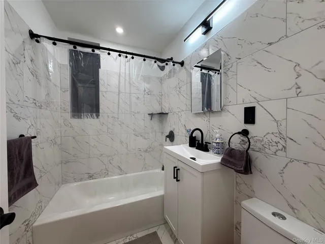 a bathroom with a bathtub sink vanity and toilet