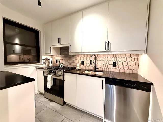 a kitchen with granite countertop a sink stainless steel appliances and cabinets