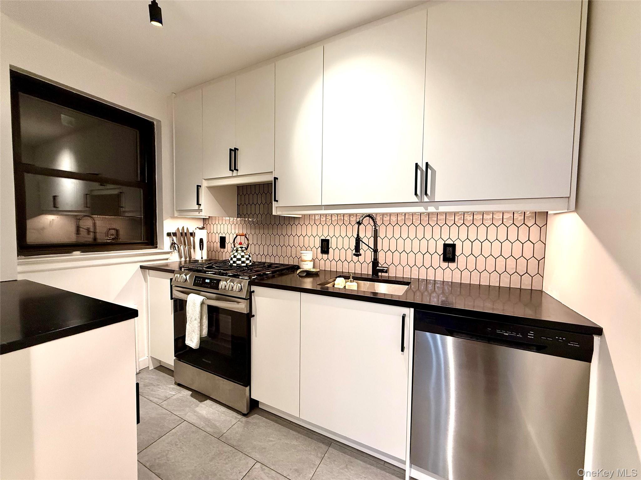 112-30 Northern Boulevard, Unit 2A Queens, NY 11368 - Photo 9 of 40 Kitchen featuring stainless steel appliances, white cabinetry, light tile patterned floors, and modern cabinets