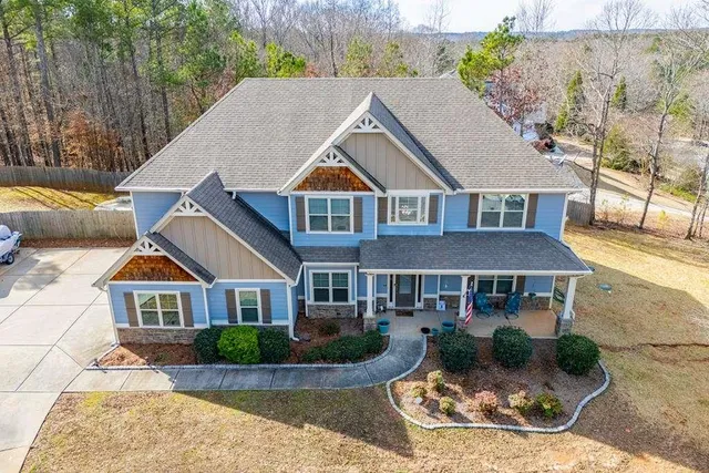 an aerial view of a house with swimming pool and large trees