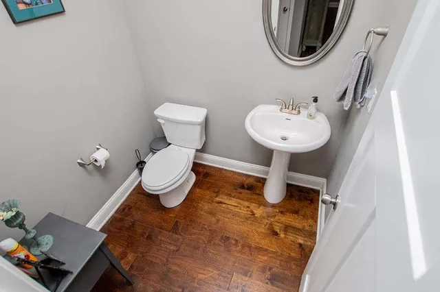 a bathroom with a granite countertop sink a toilet and a mirror