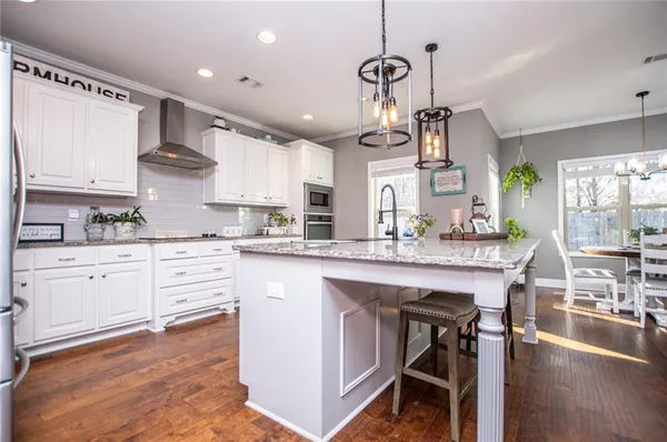 a kitchen with granite countertop white cabinets and stainless steel appliances