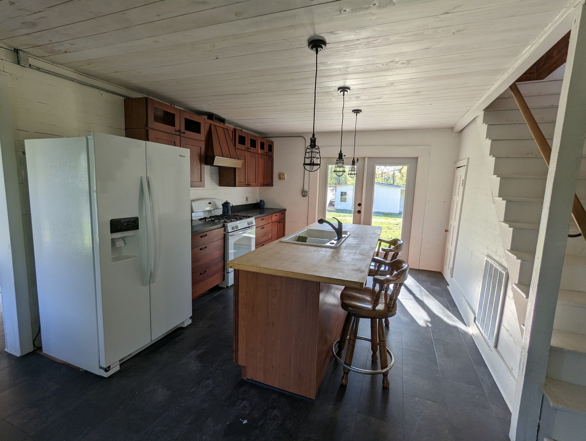 1097 Lower Lick Creek Road Linden, TN 37096 - Photo 5 of 45 a kitchen with stainless steel appliances a refrigerator a stove a sink dishwasher and a dining table with wooden floor