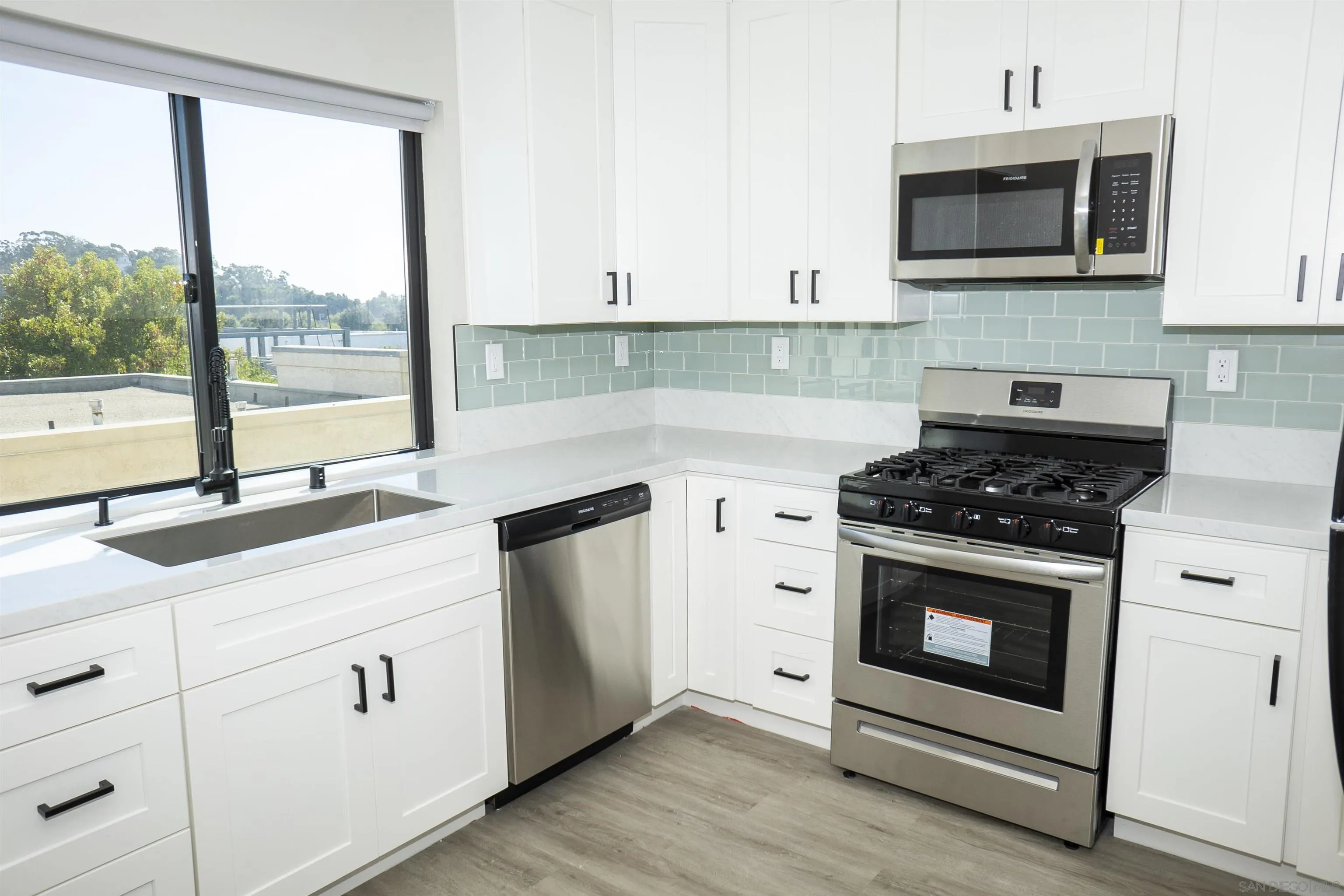 5548 Riley Street San Diego, CA 92110 - Photo 8 of 15 a kitchen with granite countertop white cabinets stainless steel appliances and a sink