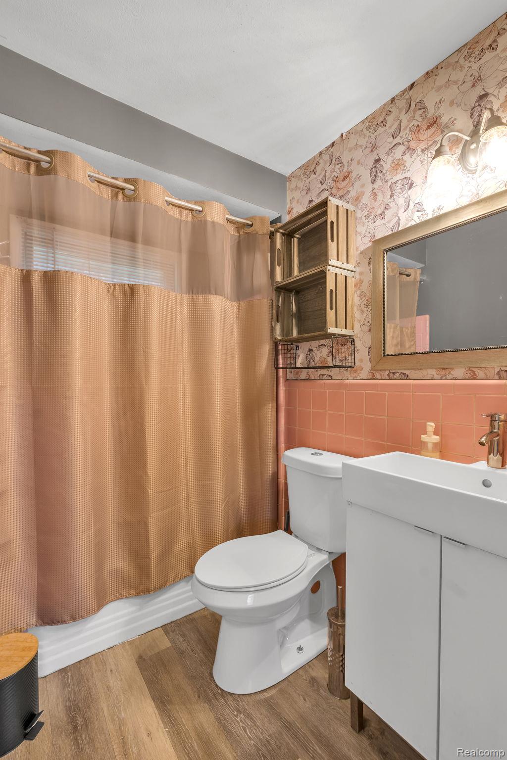 37022 Pinewood Road Wayne, MI 48184 - Photo 11 of 30 Bathroom with wallpapered walls, vanity, light wood-style floors, a wainscoted wall, and tile walls