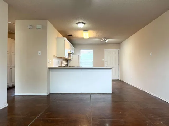 a view of kitchen with kitchen island a sink wooden floor and a refrigerator