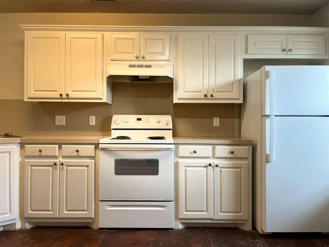 a kitchen with white cabinets and white appliances