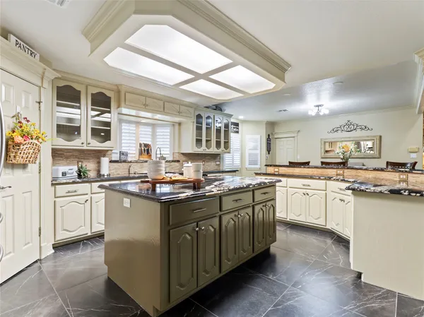 a kitchen with stainless steel appliances granite countertop a stove and more cabinets