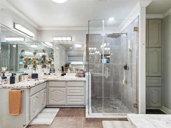 a large bathroom with a shower sink and mirror
