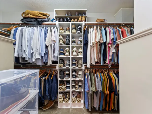 a view of walk in closet with clothes and shoes
