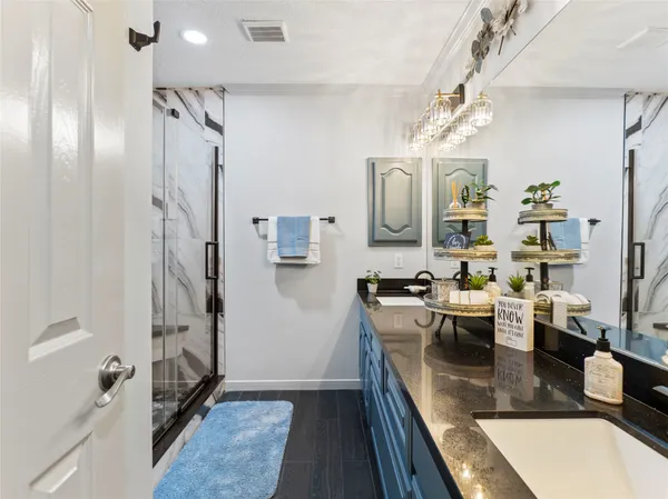 a kitchen with stainless steel appliances granite countertop a refrigerator a sink dishwasher a oven with white cabinets and wooden floor
