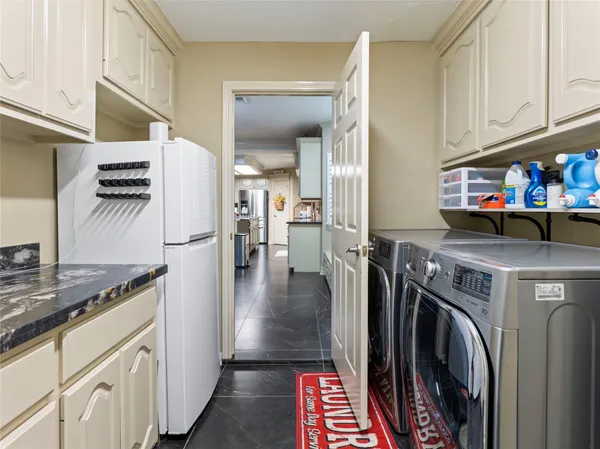 a view of a kitchen with fridge and wooden floor