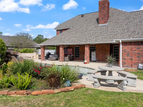 a view of a house with backyard sitting area and garden