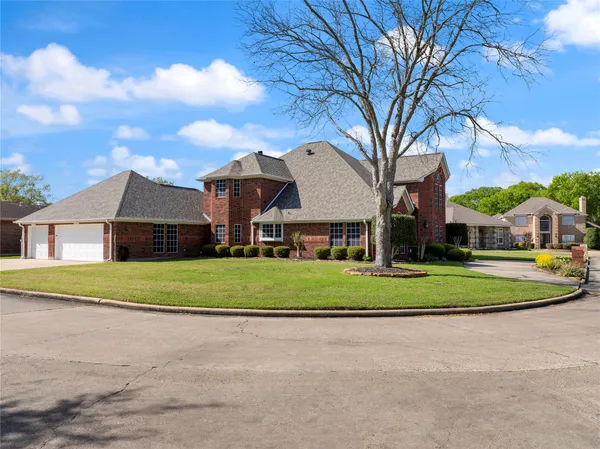 a view of a big house with a big yard and large trees