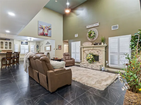 a living room with fireplace furniture and a potted plant