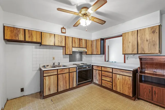 a kitchen with stainless steel appliances granite countertop a stove sink and cabinets