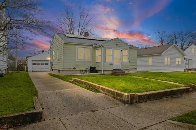 a view of a house with a backyard and a garage