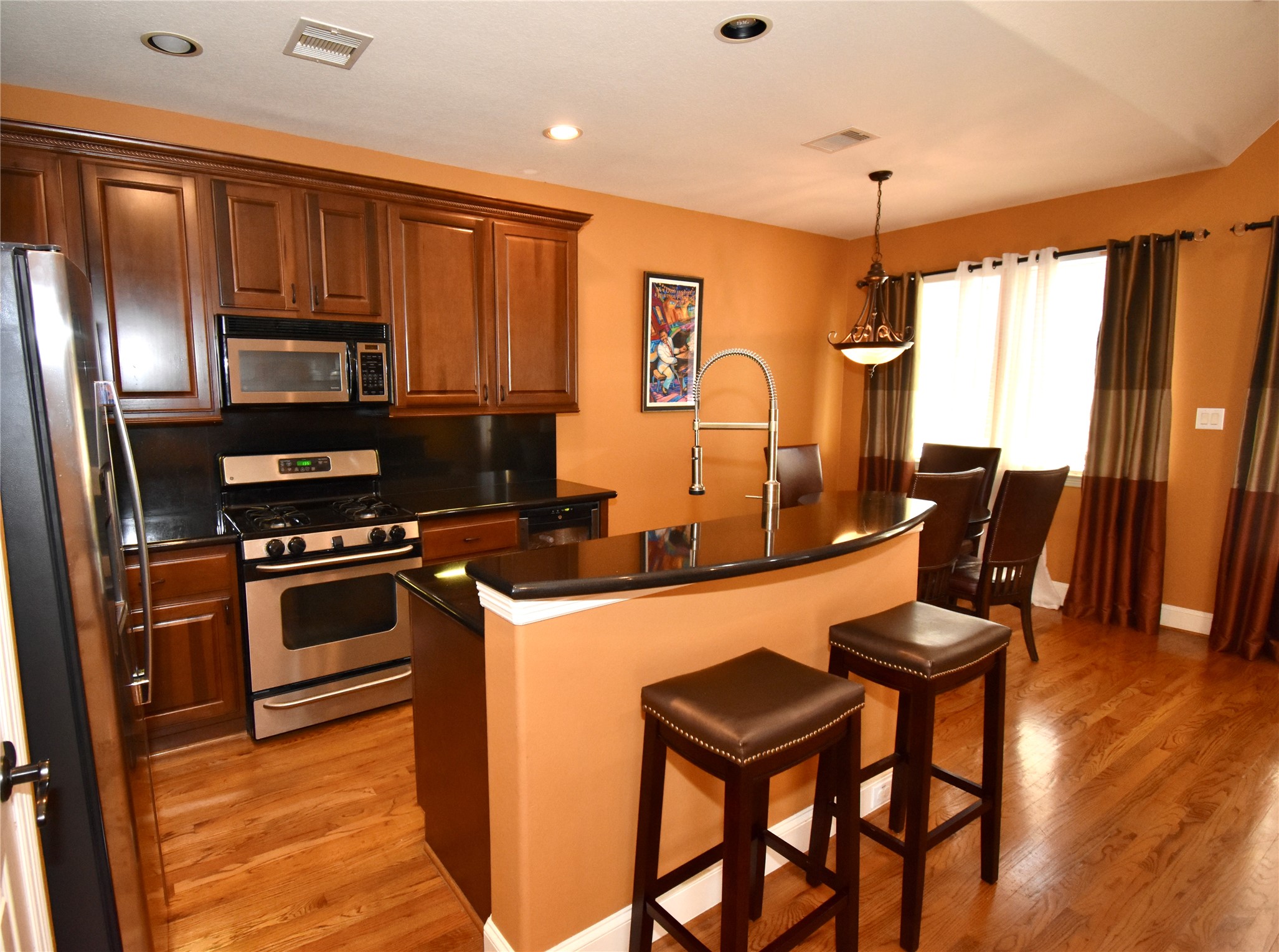 326 Gregg Street Houston, TX 77020 - Photo 12 of 26 a kitchen with stainless steel appliances granite countertop a stove a refrigerator a sink a dining table and chairs with wooden floor