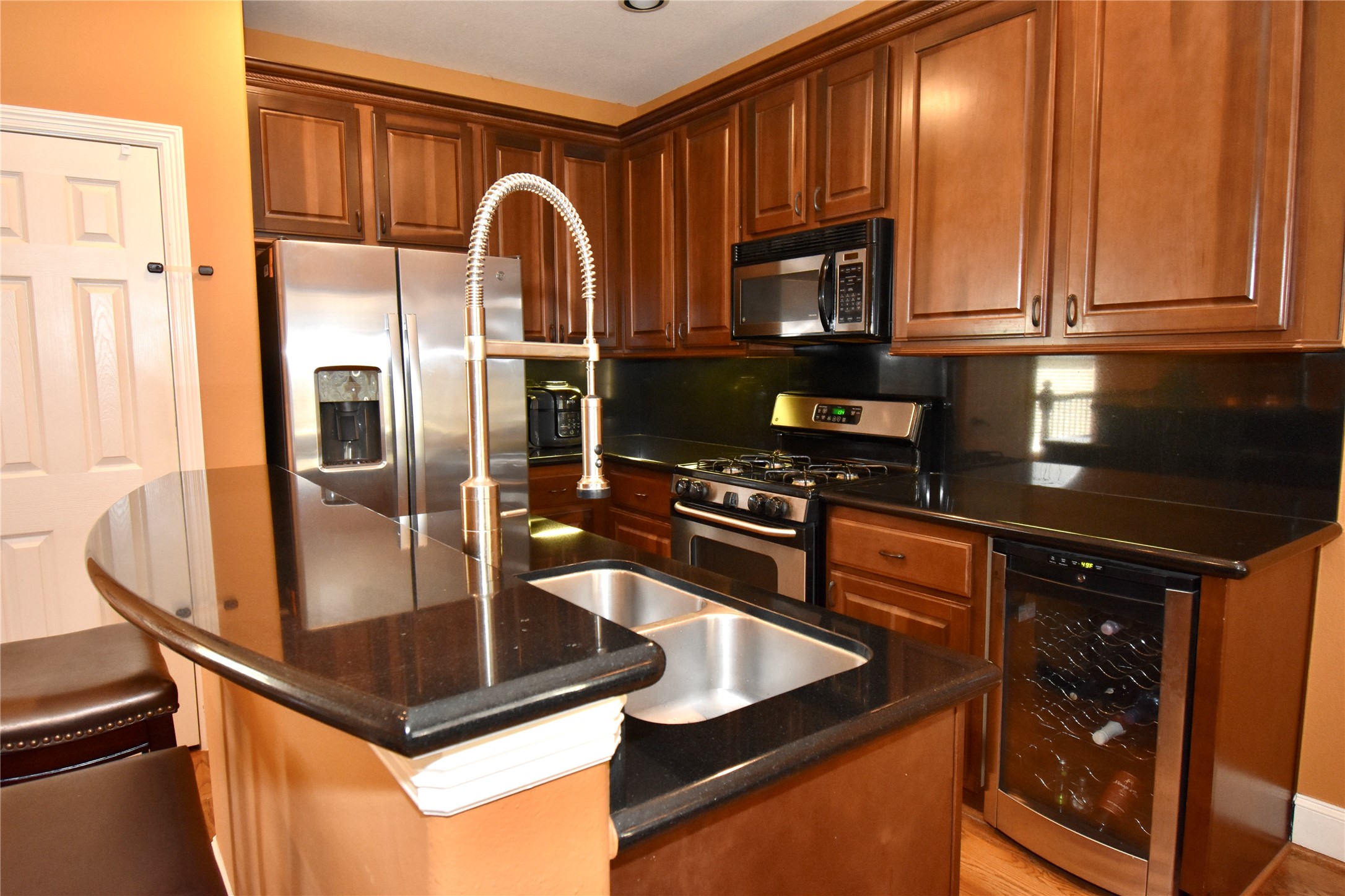 326 Gregg Street Houston, TX 77020 - Photo 13 of 26 a kitchen with stainless steel appliances granite countertop a refrigerator a stove and a sink with wooden floor