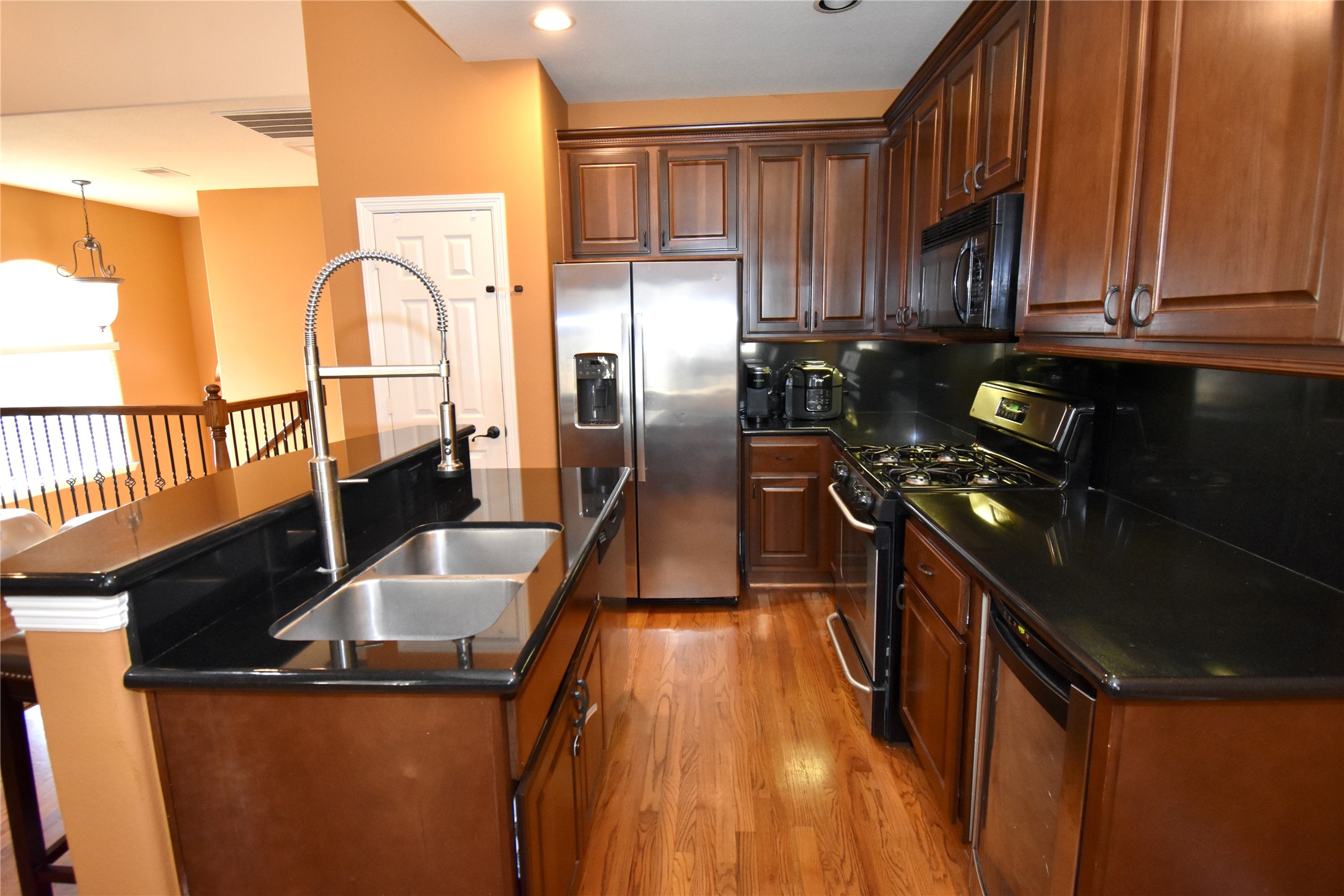 326 Gregg Street Houston, TX 77020 - Photo 14 of 26 a kitchen with granite countertop a refrigerator a stove top oven and a sink with wooden floor