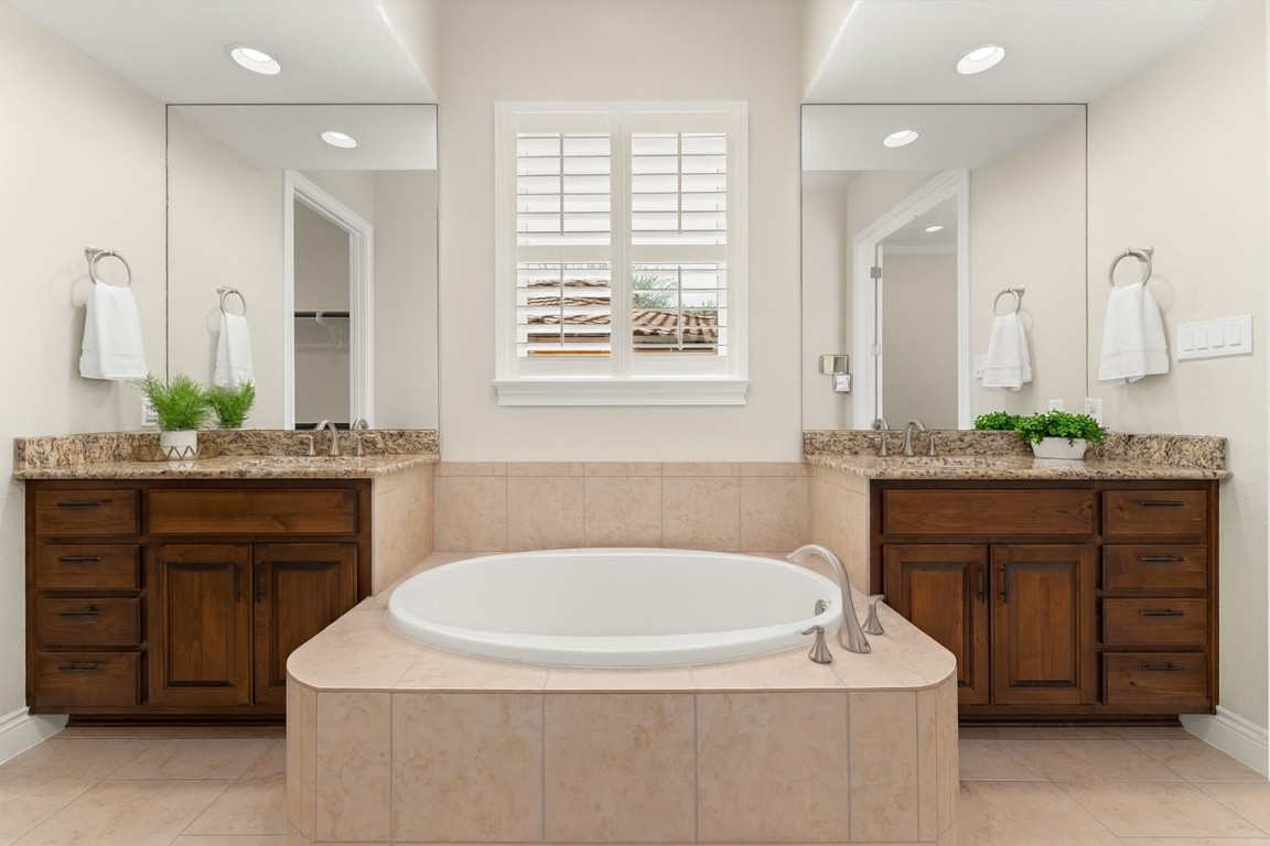 404 Amiata Avenue, Unit 34 Austin, TX 78734 - Photo 7 of 35 a bathroom with a granite countertop sink a bathtub a mirror and vanity