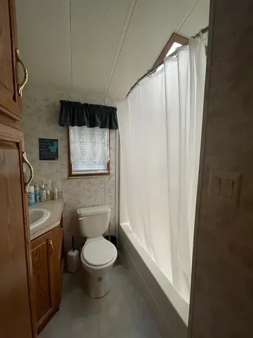 a bedroom with a bed and a flat tv screen on dresser