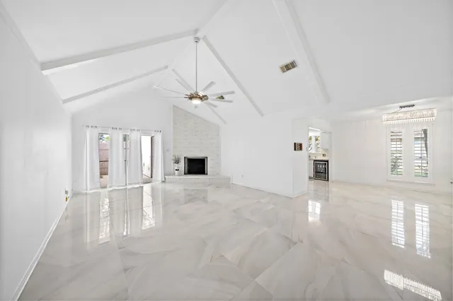 an empty room with windows and fireplace