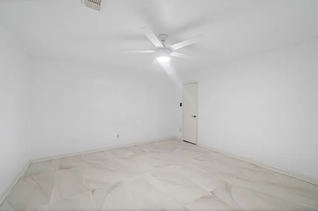 an empty room with closet and fan
