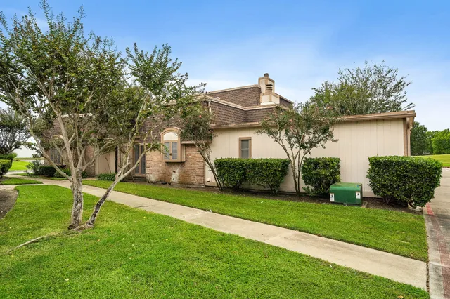 a front view of a house with a yard and trees