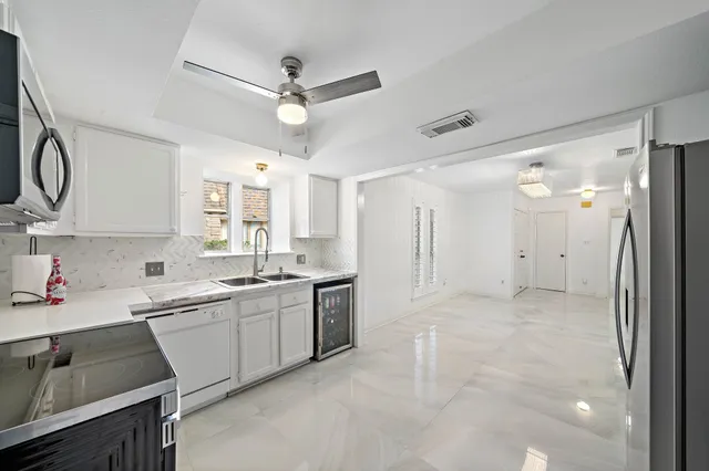 a kitchen with a sink refrigerator and cabinets