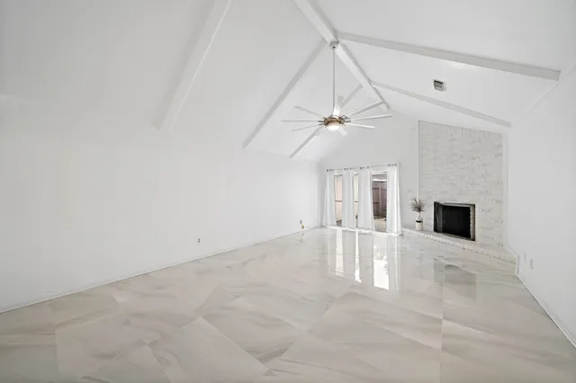 an empty room with windows and fireplace