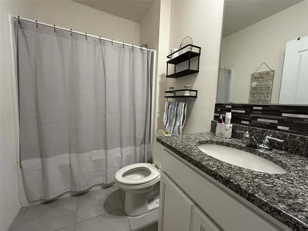 a bathroom with a granite countertop sink toilet and shower