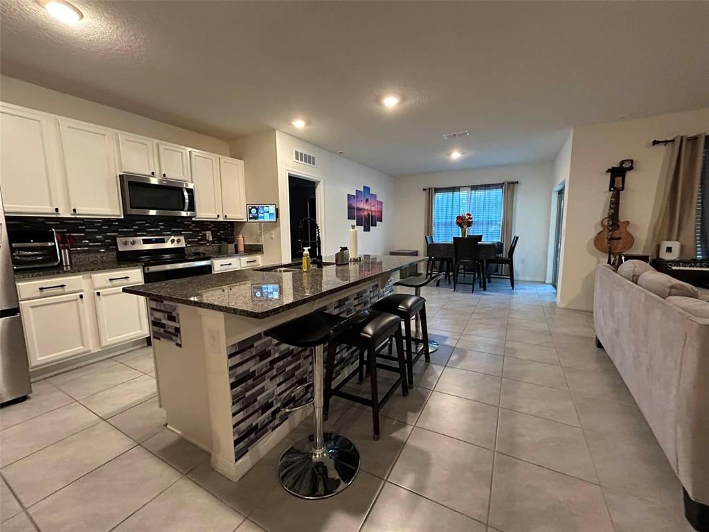 2612 Harmonia Hammock Road Harmony, FL 34773 - Photo 5 of 17 a kitchen with stainless steel appliances a stove a sink a microwave and a refrigerator