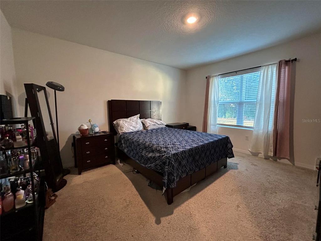 2612 Harmonia Hammock Road Harmony, FL 34773 - Photo 10 of 17 a bedroom with a bed and a flat tv screen on a dresser